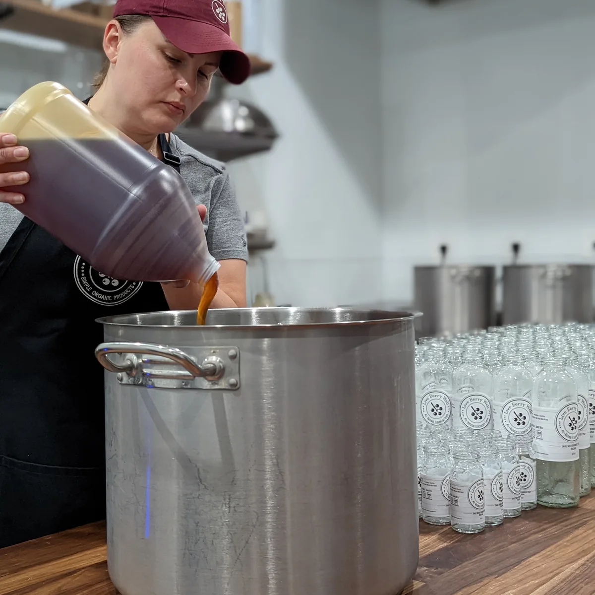 Erica handcrafting elderberry syrup with raw honey in the Live Berry Well kitchen